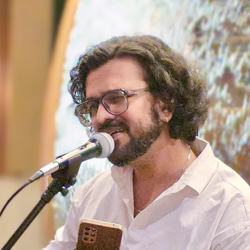 Portrait of Aniket Patel singing at a microphone