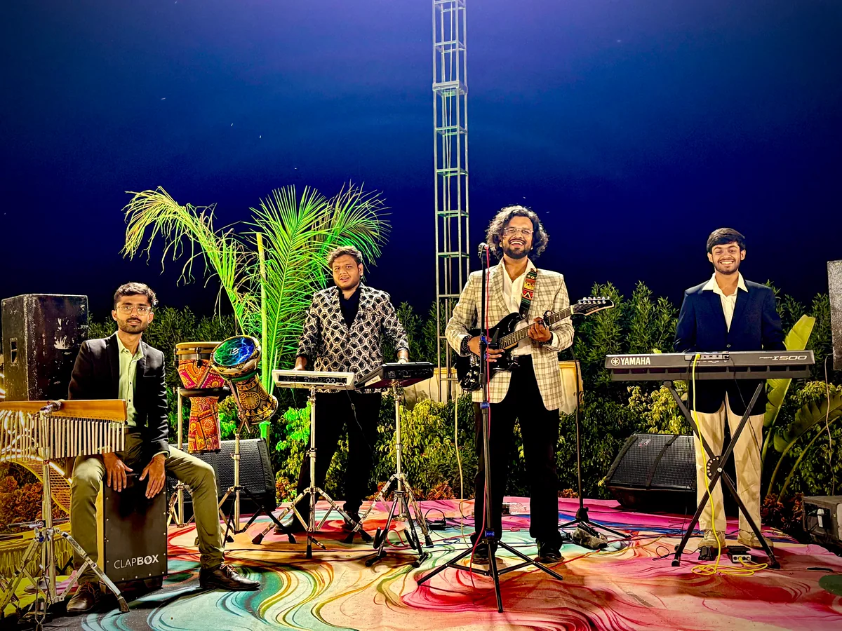 Aniket Patel & Band performing on stage at night with the full line-up