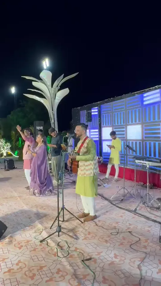 Aniket Patel & Band performing on an outdoor stage in the evening